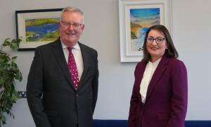 The Health Minister Mike Nesbitt standing beside Ema Cubitt the Autism Reviewer in an office.