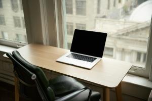 Photograph of a office desk, chair and laptop.